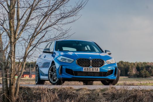 Blå BMW M135i vid ett träd