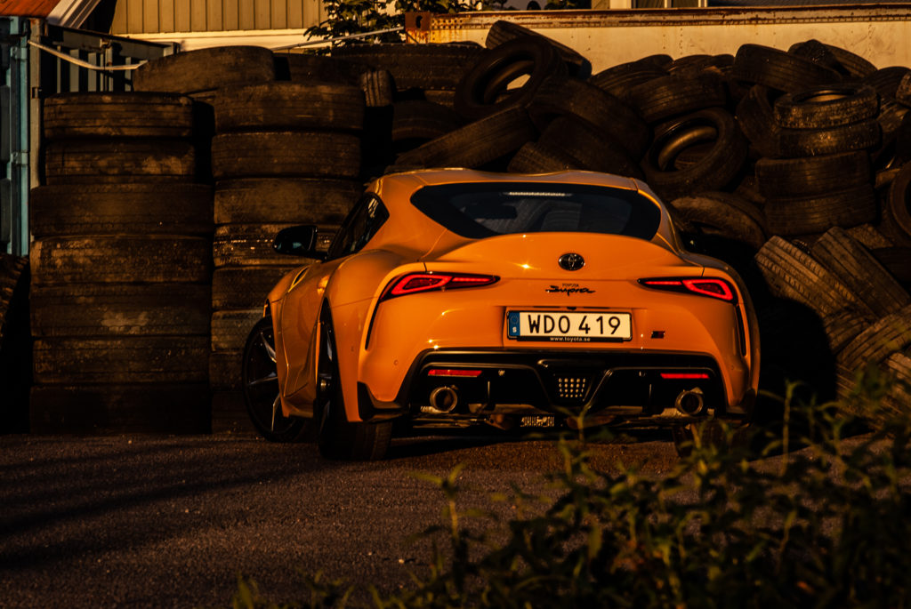 Gul Toyota GR Supra vid däckhög
