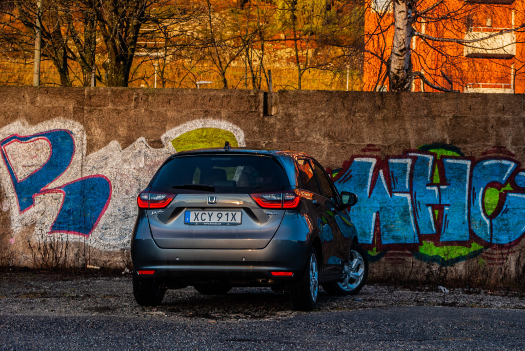 grå honda jazz vid graffitivägg
